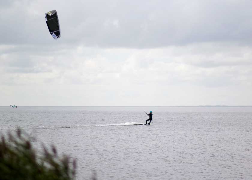 Kitesurferen har fået god vind i kite'en og turen går i raskt tempo ud over fjordens bølger