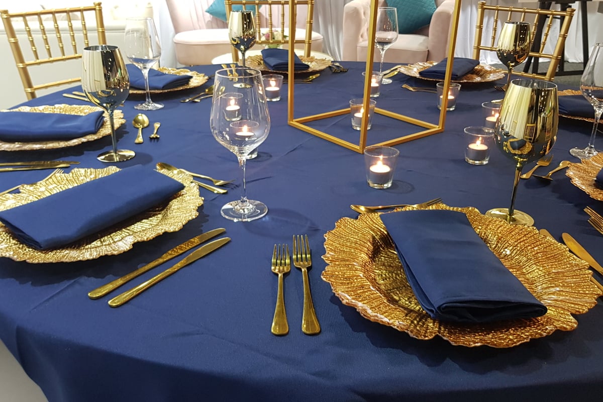 Gold Flared Charger Plate with Navy Napkin and Tablecloth