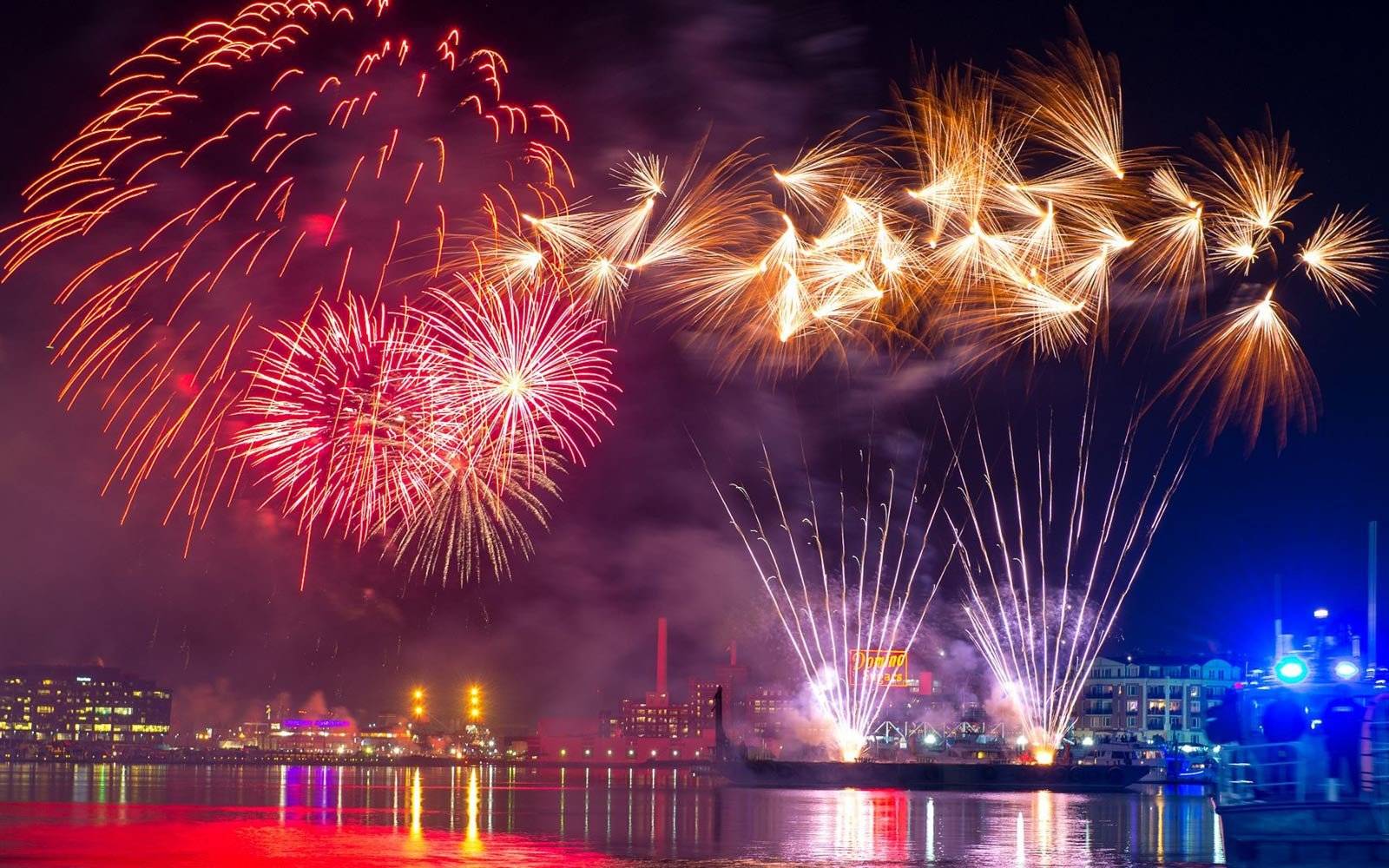 A colorful fireworks display over a body of water.
