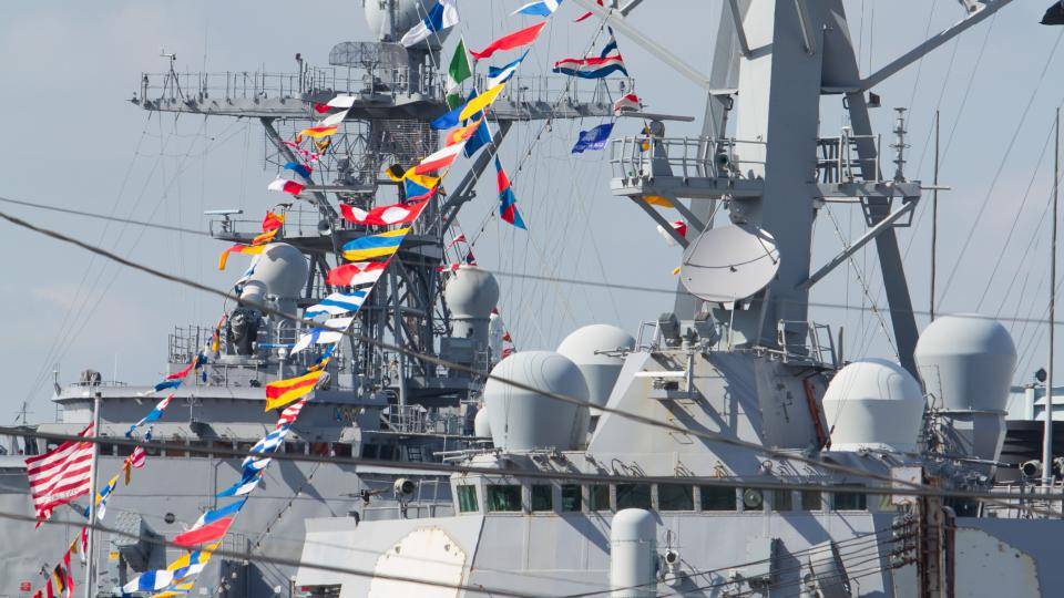 A navy ship with flags.