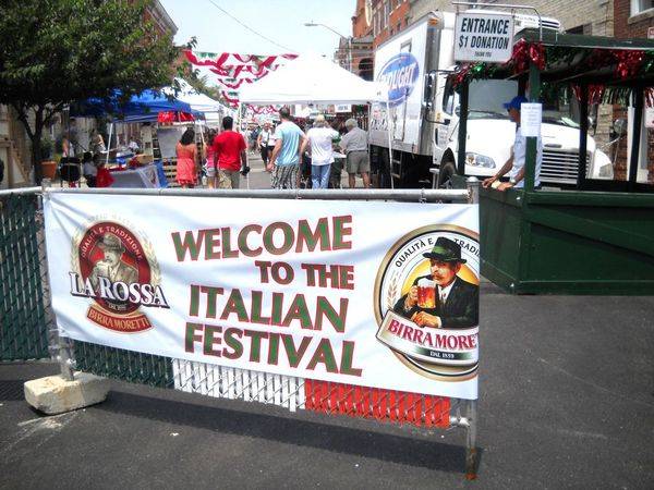 A sign welcomes people to the italian festival.